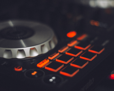 Kontroler DJ z podświetlanymi pomarańczowymi przyciskami